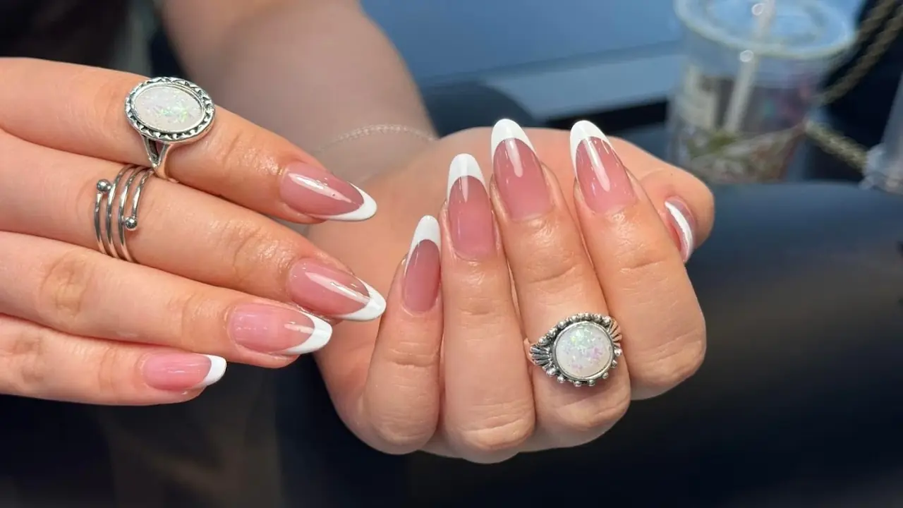 Soft pink French nails and rings, done at Focus Nails Bondi Junction